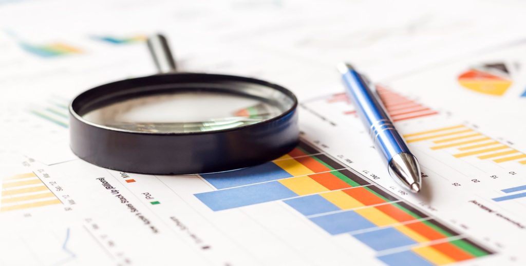 Magnifier and pen on chart graph paper